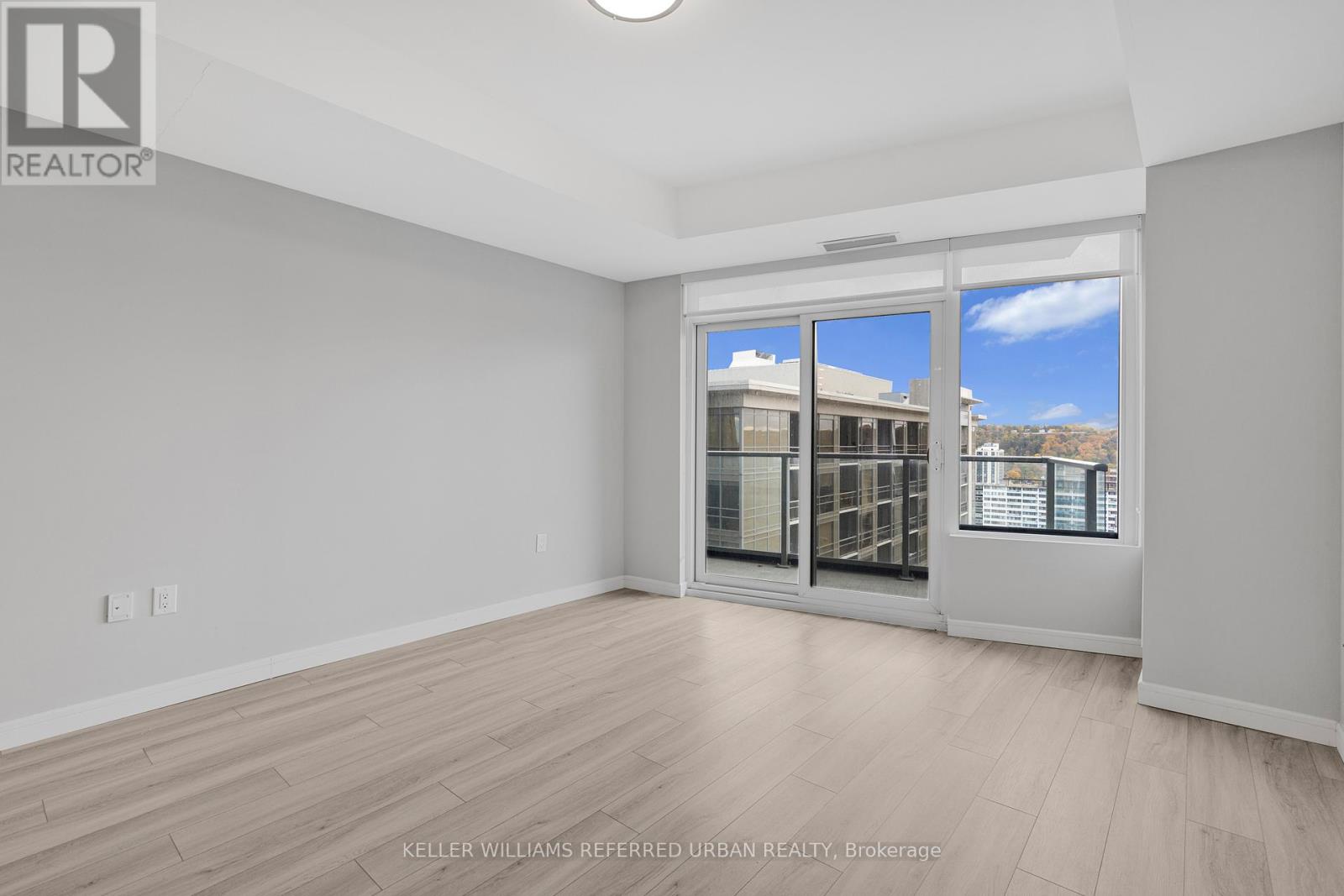A spacious room with a view of the city through the windows.