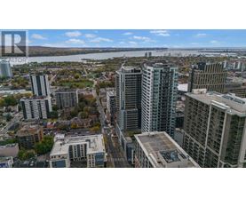 A cityscape with tall buildings and a river in the background.