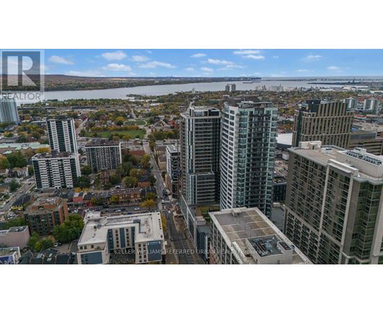 A cityscape with tall buildings and a river in the background.