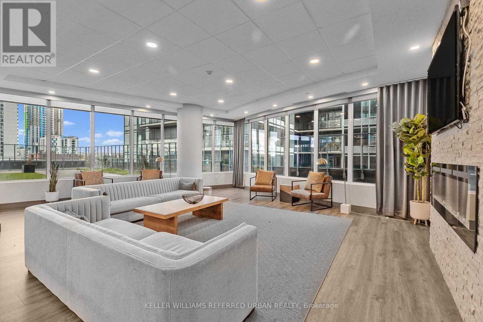 A spacious living room with a large grey sofa and a wooden coffee table.