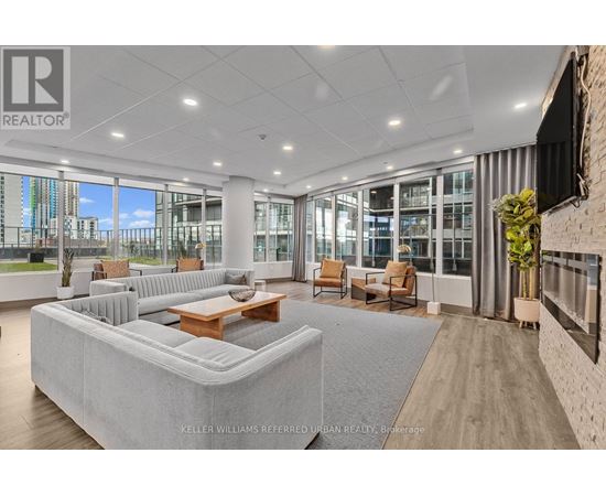 A spacious living room with a large grey sofa and a wooden coffee table.