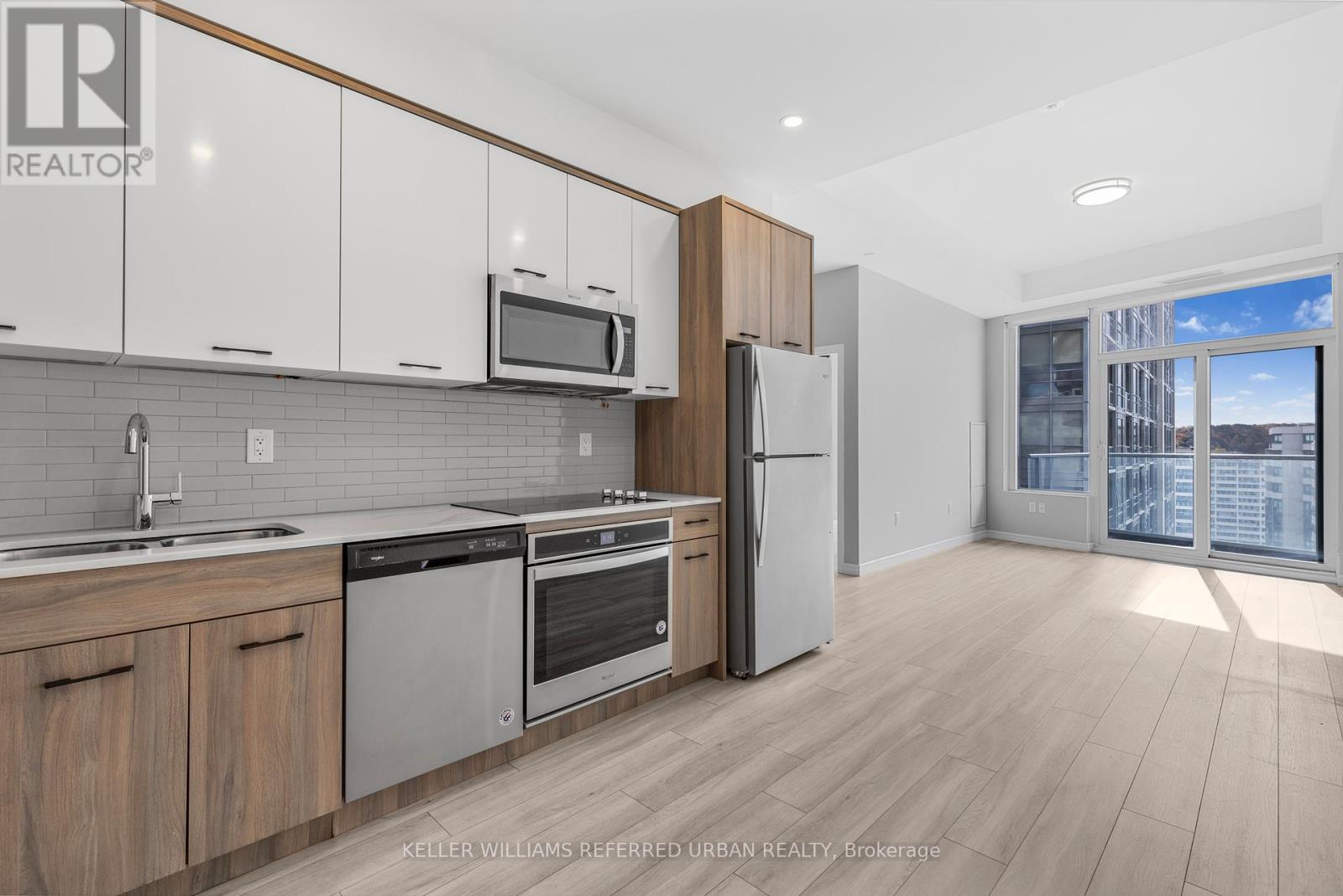 A modern kitchen with wooden cabinets and stainless steel appliances.