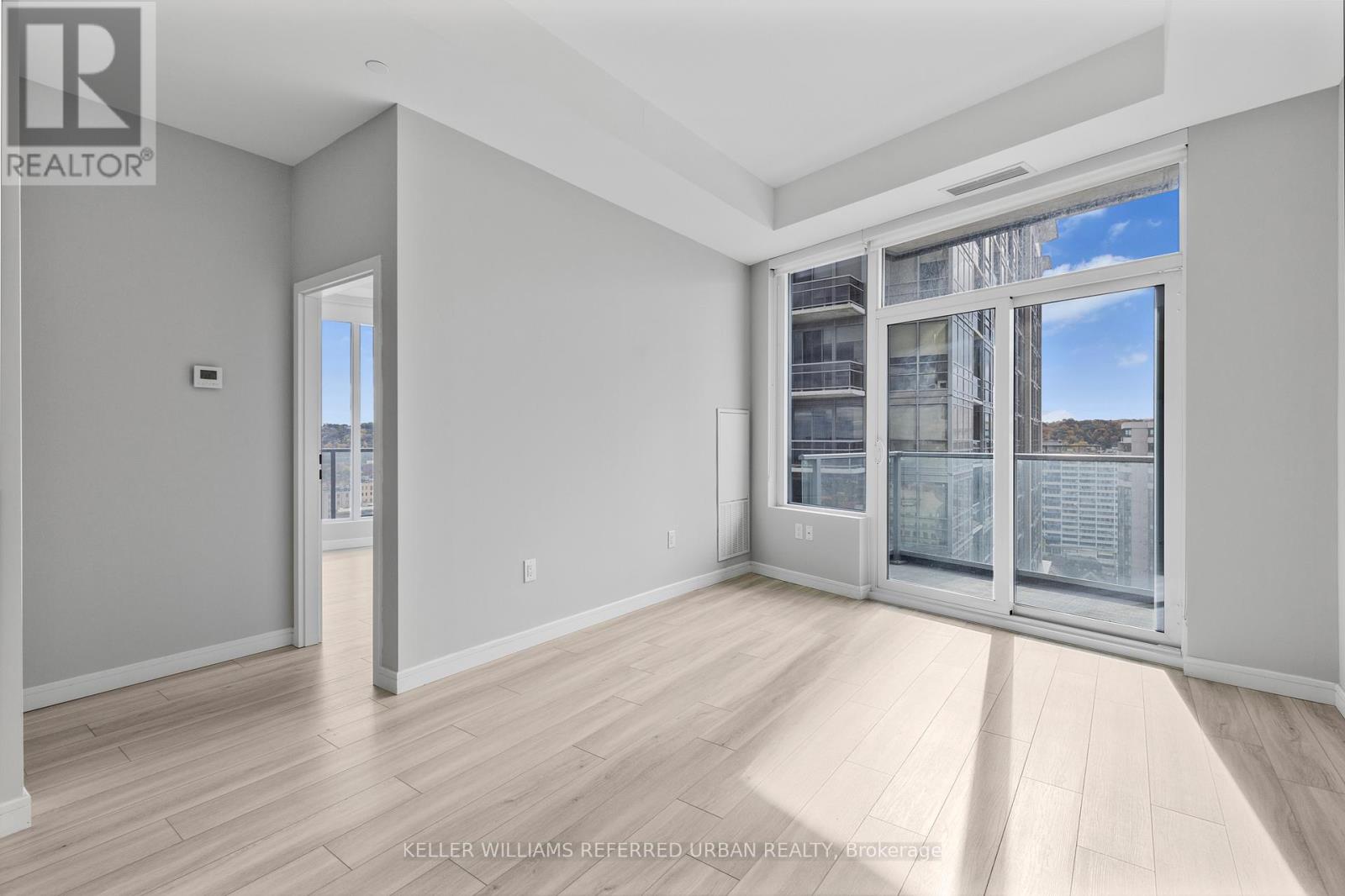 A spacious room with a view of the city through the windows.