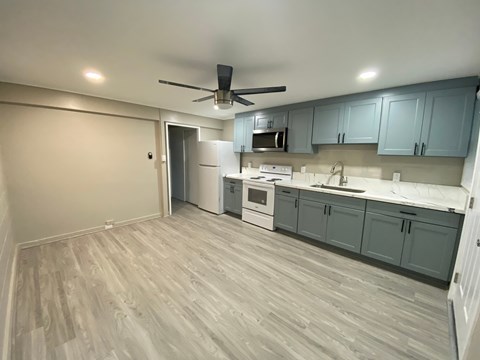 A kitchen with a white oven and a ceiling fan.