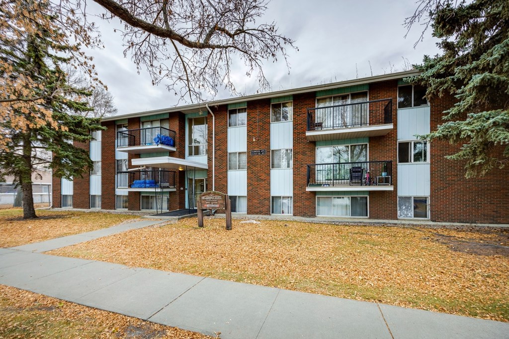 Apartment building with a sign in front of it.