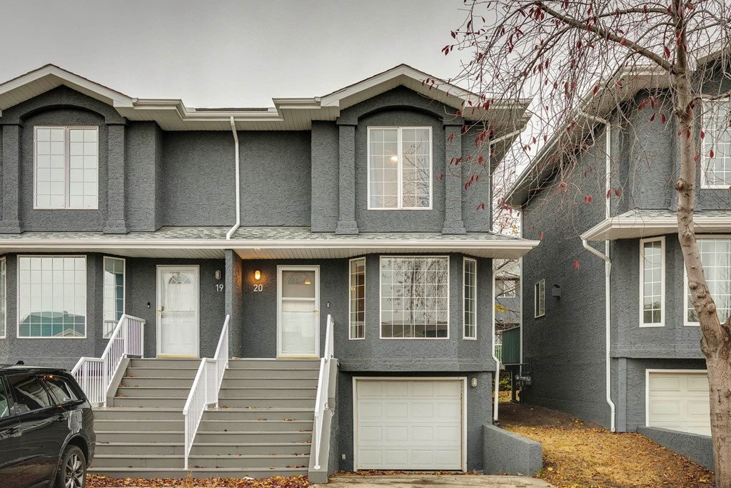 A grey house with a white door and windows.