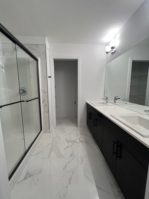A bathroom with a marble floor and a large mirror.