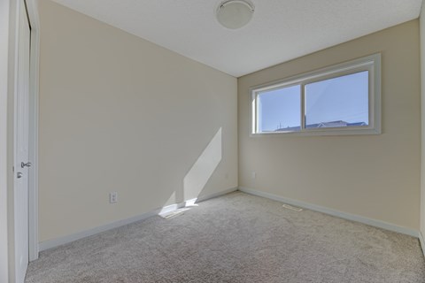 A room with a carpeted floor and a window.