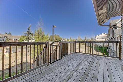 A wooden deck with a metal railing and a lamp post.