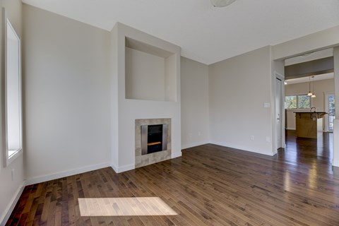 A room with a fireplace and wooden floors.