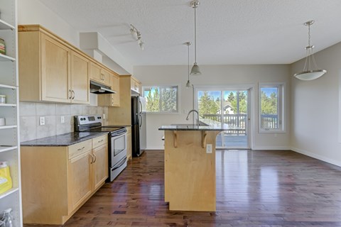A kitchen with wooden cabinets and a black countertop.