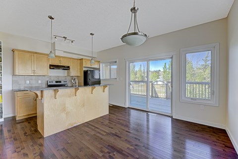 A kitchen with wooden floors and a countertop with a sink.