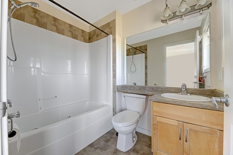 A white bathroom with a toilet, sink, and bathtub.