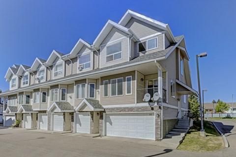 A large, modern residential building with multiple garages.