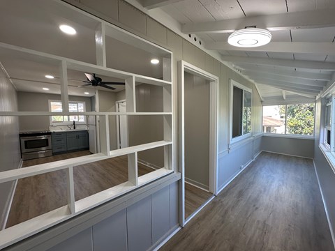 A room with a ceiling fan and a microwave.