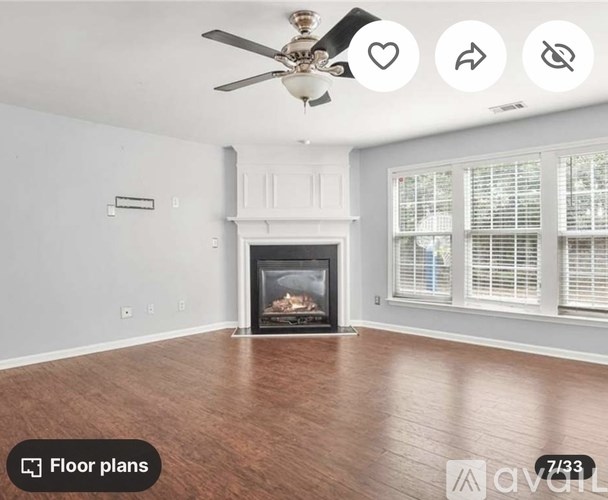 A living room with a fireplace and a ceiling fan.