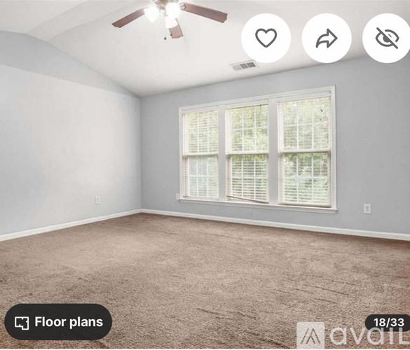 A room with a carpeted floor and a window with blinds.