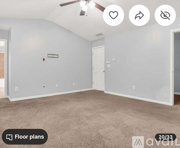 A room with a carpeted floor and a ceiling fan.