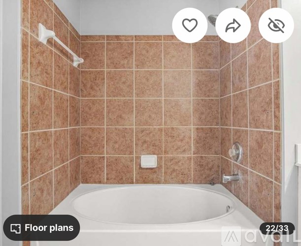 A bathroom with a tub and tiled walls.