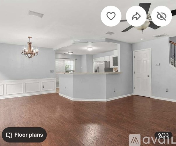 A spacious room with a chandelier and a ceiling fan.