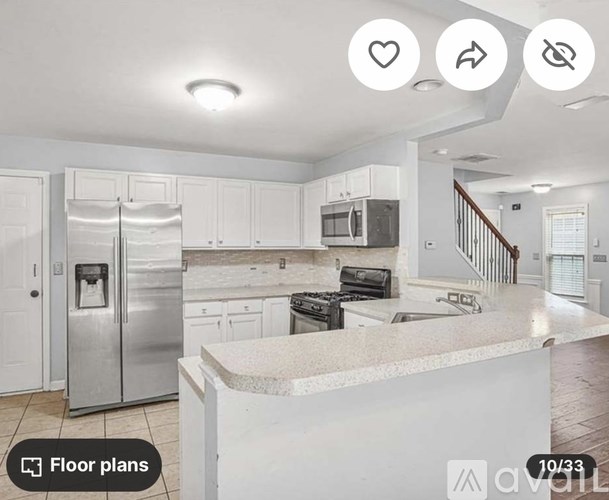 A kitchen with white cabinets and a stainless steel refrigerator.