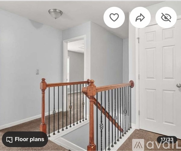 A white room with a wooden railing and a white door.