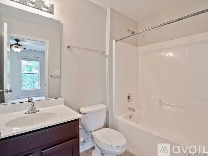 A bathroom with a toilet, sink, and bathtub.