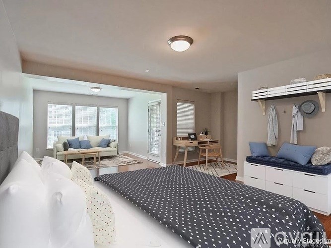 A bedroom with a large bed and a couch in the living area.