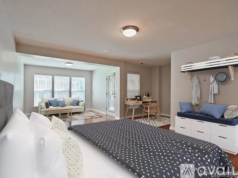 A bedroom with a large bed and a couch in the living area.