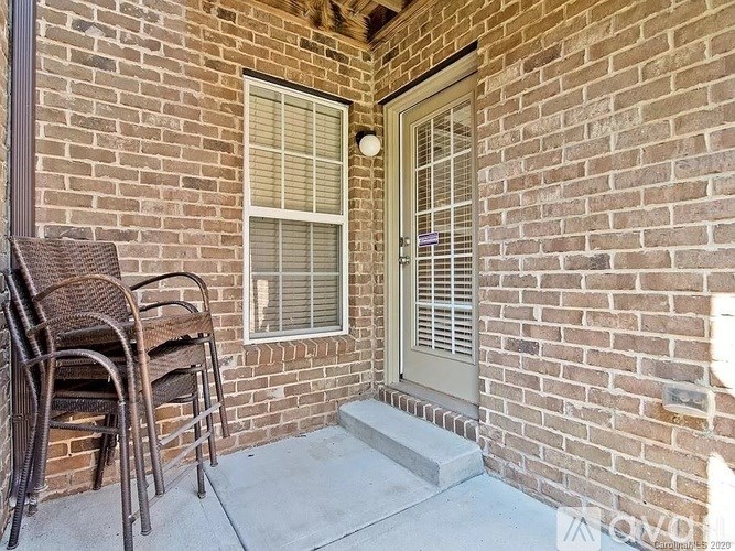 A patio with a door and chairs.
