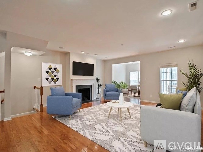 A living room with a fireplace and a TV on the wall.