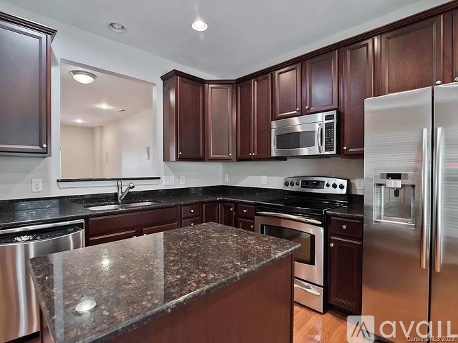 A kitchen with dark brown cabinets and stainless steel appliances.