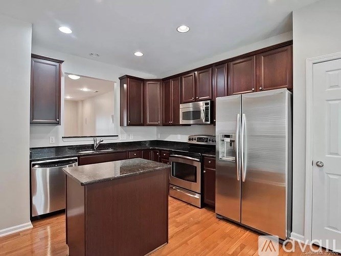 A kitchen with brown cabinets and stainless steel appliances.