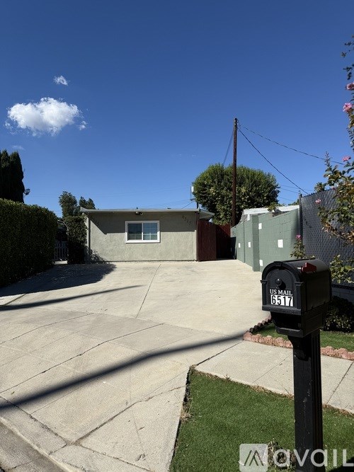 A house with a driveway and a mailbox with the number 6517 on it.