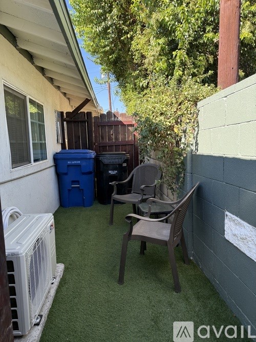 A patio with a chair, table, and a wall with a sign on it.