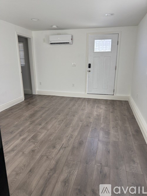 A room with a wooden floor and a white door.