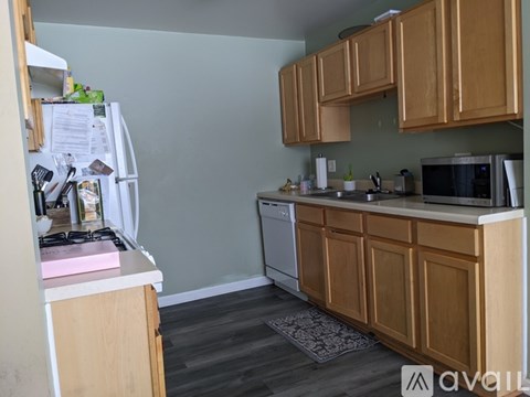 A kitchen with wooden cabinets and a white fridge.
