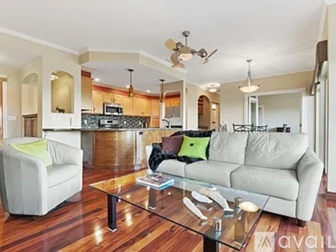 A living room with a white couch and a glass coffee table.