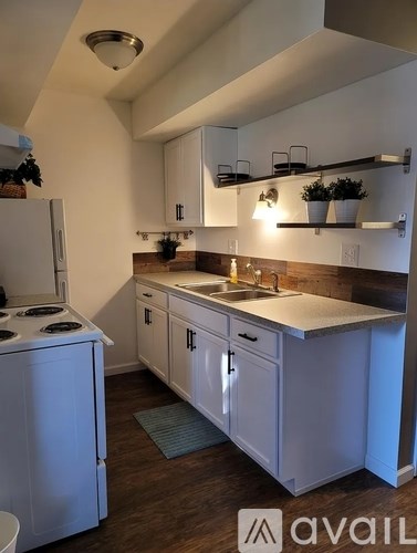 A kitchen with white appliances and cabinets.