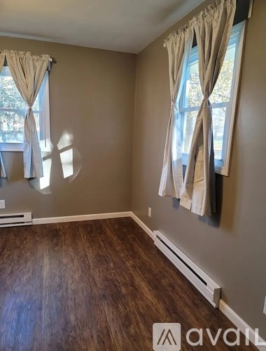 A room with a window and curtains.