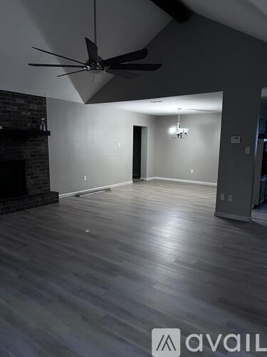 A room with a ceiling fan and a fireplace.