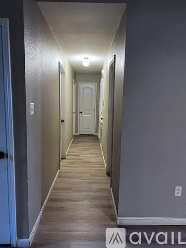 A long hallway with doors on both sides and a light on.