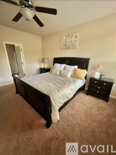 A bedroom with a bed, dresser, and ceiling fan.