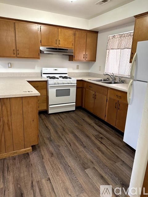 A kitchen with wooden cabinets and a white refrigerator.