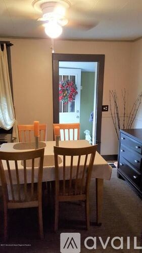 A dining room with a table and chairs.