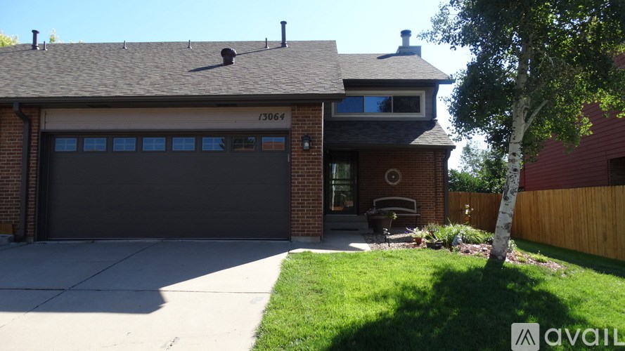 A house with a garage and a tree in front.