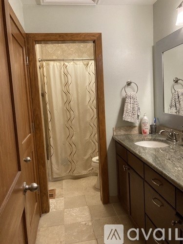 A bathroom with a glass shower door and a wooden door.