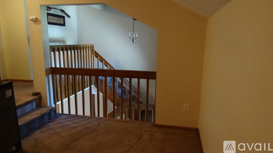 A room with a staircase and a chandelier.