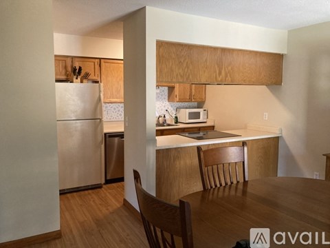 A kitchen with wooden cabinets and a white fridge.