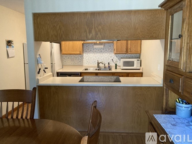 A kitchen with wooden cabinets and a countertop with a microwave on it.
